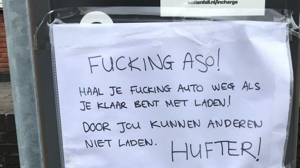 Briefje op laadpaal met de tekst 'Fucking aso'